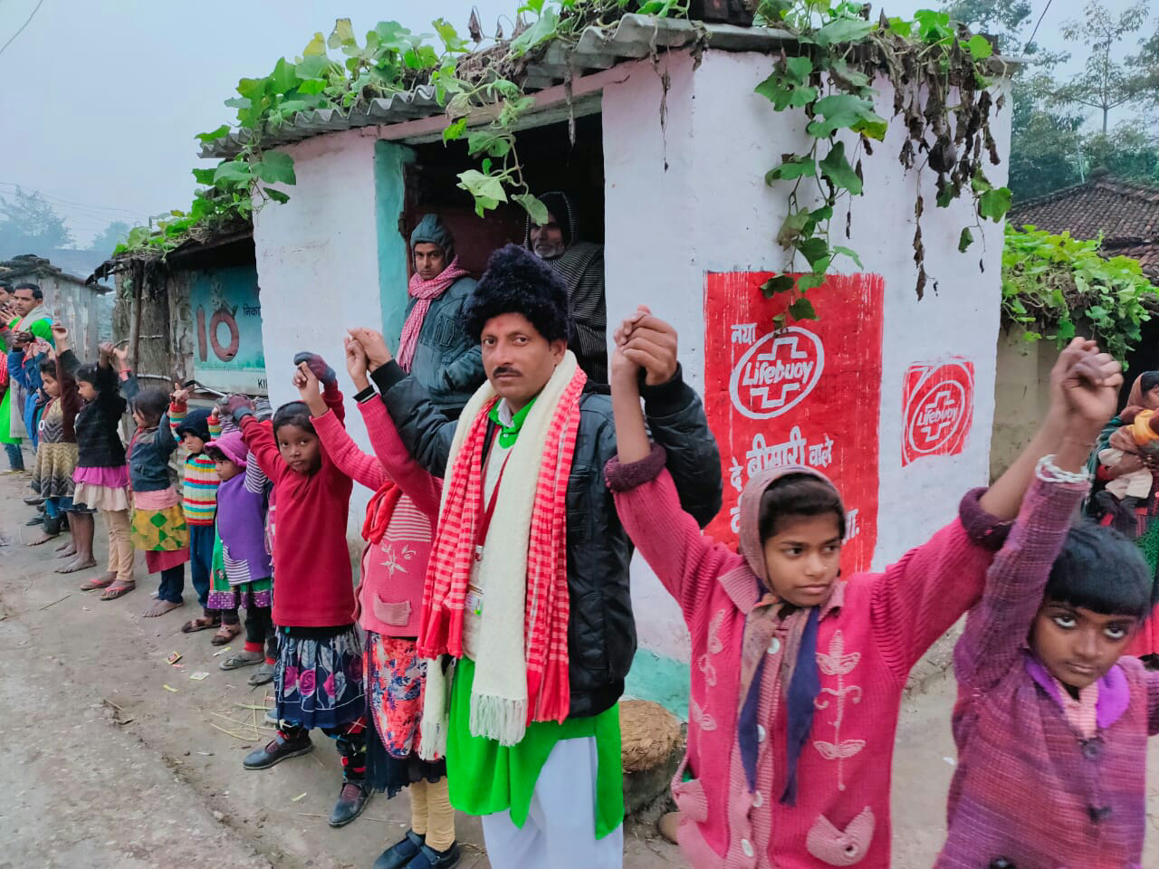मानव श्रृंखला का पूर्वाभ्यास कराने में जुटे लोकप्रिय कलाकार डी. आनंद। ग्रामीण परिवेश के छोटे-छोटे बच्चे भी काफी उत्साहित।